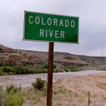 Colorado River flowing behind a sign