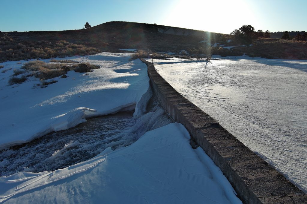 A large crack in the Panguitch Lake Dam, likely caused by high water and ice pressure, has prompted a Level 2 Emergency Situation, with authorities taking mitigating measures to prevent a potential partial breach that could flood areas of Panguitch, Utah.